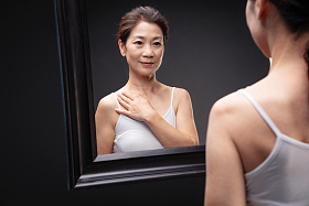 优雅的中年女性欣赏镜子中的自己