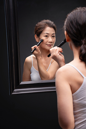 对着镜子化妆的中年女人图片