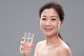 中年女人拿着玻璃杯喝水肖像图片