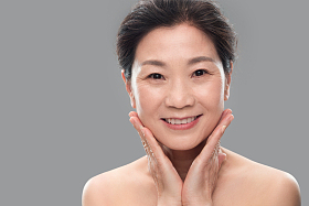 双手触摸脸颊的优雅中年女人照片