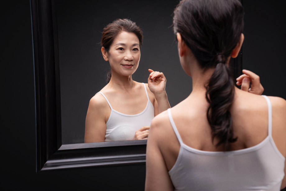 优雅的中年女性欣赏镜子中的自己 优雅的中年女性欣赏镜子中的自己