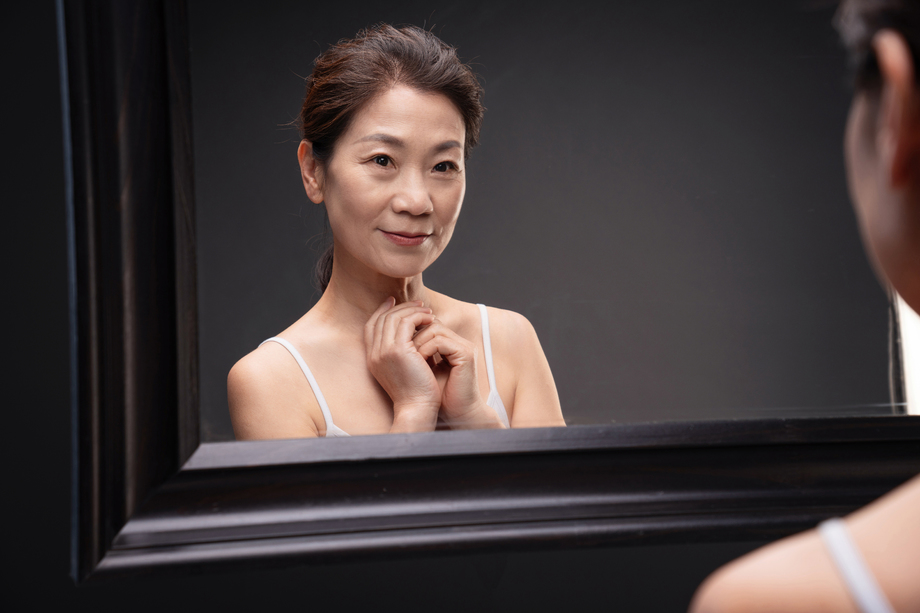 中年女性欣赏镜子中的自己