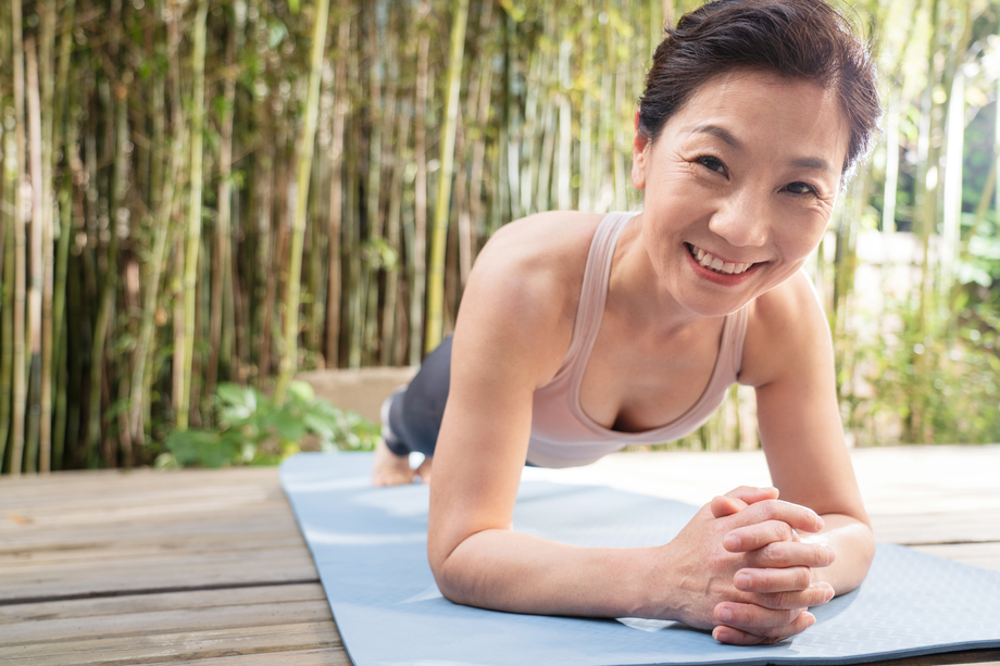 户外中老年女士趴着练瑜伽图片