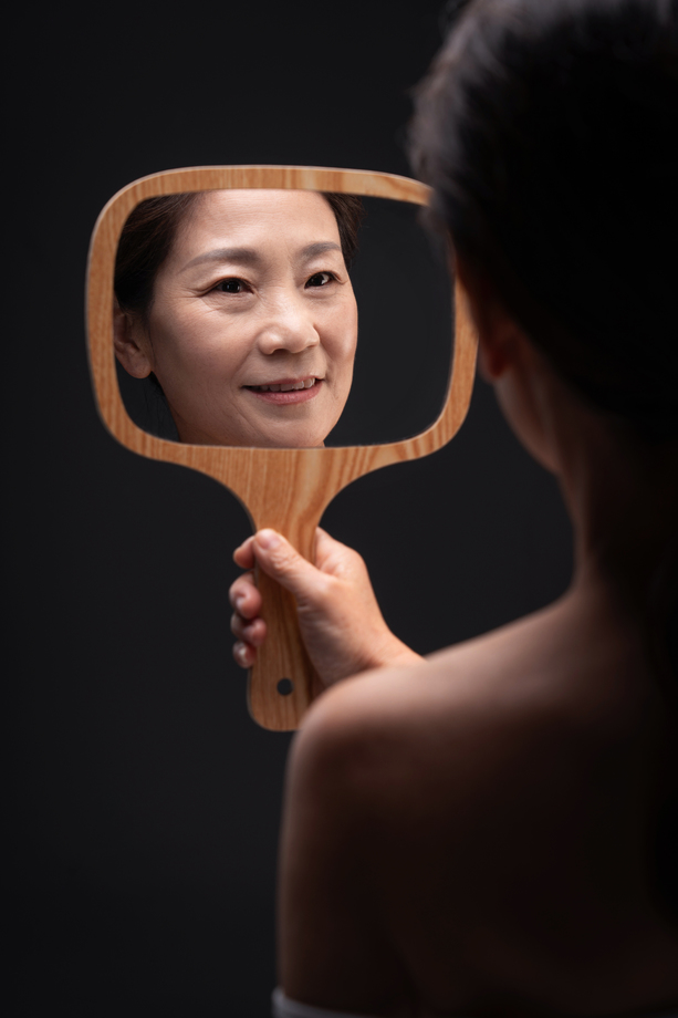 拿着镜子照的中年女人 拿着镜子照的中年女人