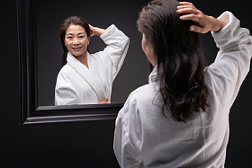 照镜子捋头发的优雅中年女人