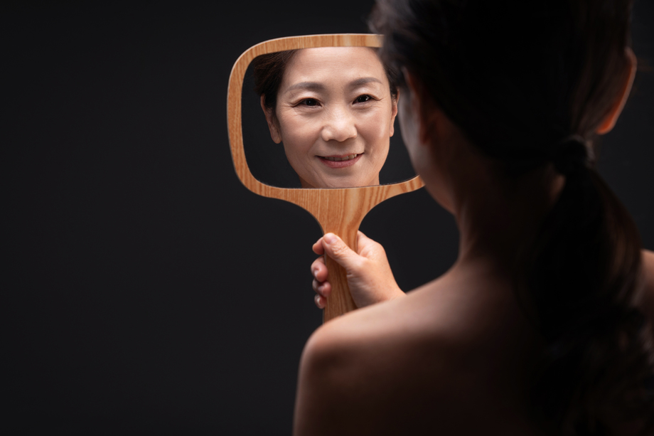 拿着镜子照的中年女人 拿着镜子照的中年女人