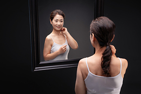 中年女性欣赏镜子中的自己图片