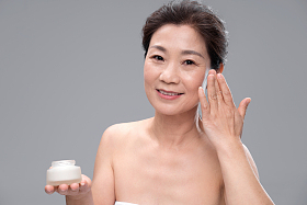 漂亮的中年女人使用护肤