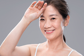用手背触摸额头的中年女人照片