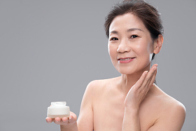 漂亮的中年女人使用护肤