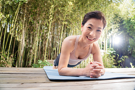 户外中老年女士趴着练瑜伽图片
