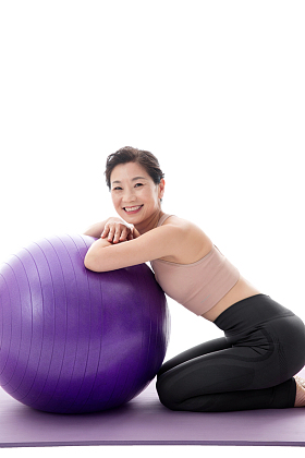趴在瑜伽球上的中年女人图片