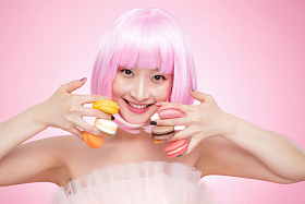 手指夹满马卡龙的年轻女孩