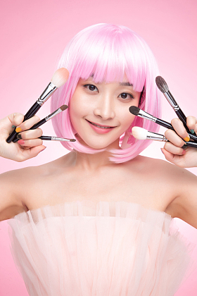 手指夹满化妆刷的年轻女孩