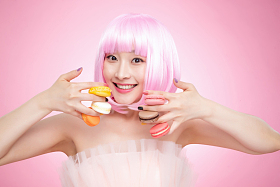 手指夹着马卡龙的年轻女孩图片