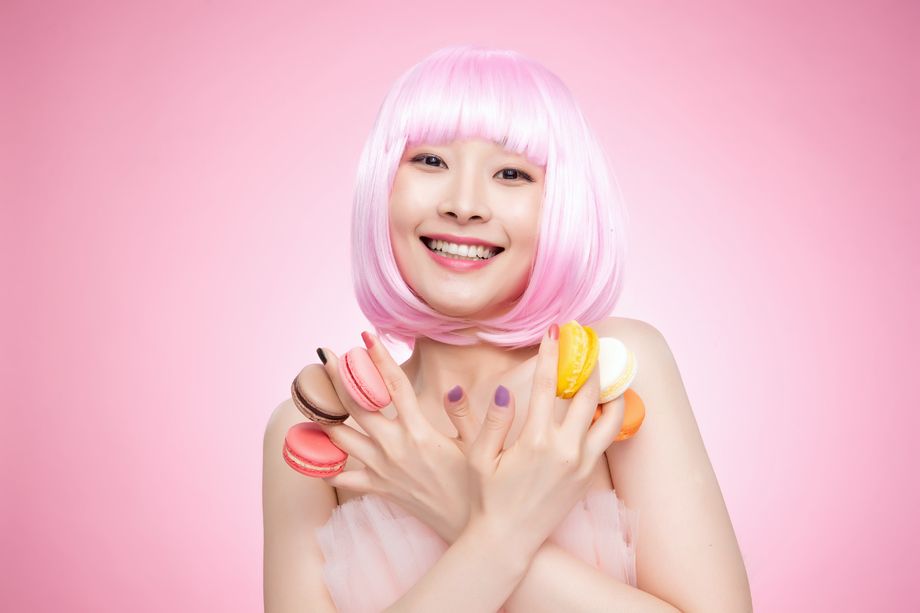 手指夹着马卡龙的年轻女孩图片 手指夹着马卡龙的年轻女孩图片