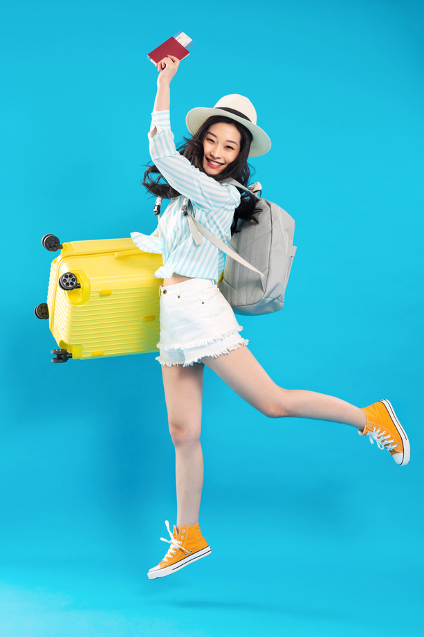 拿着行李箱去旅行的快乐女孩照片