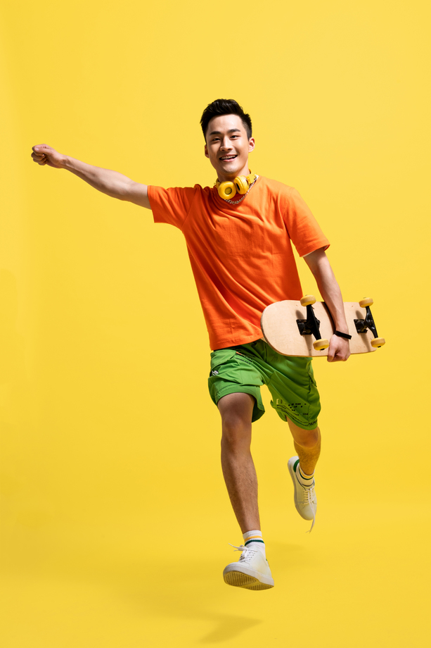 拿着滑板的青年男人 拿着滑板的青年男人