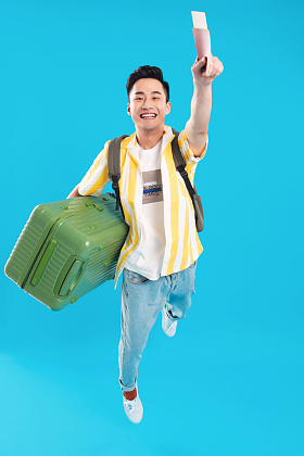 抱着行李箱去旅行的年轻男人