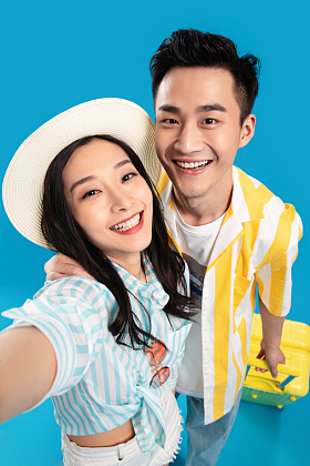 青年情侣拉着行李箱去旅游