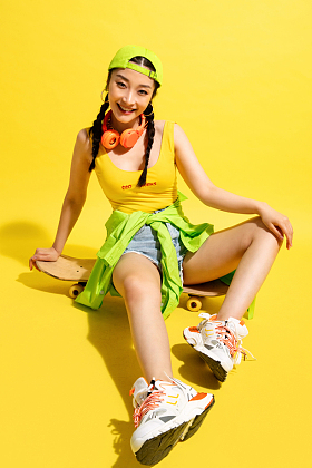 坐在滑板上休息的年轻女孩照片