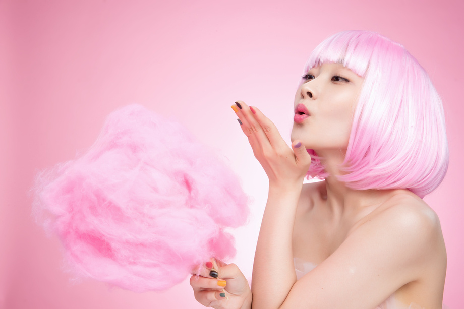 拿着棉花糖玩耍的年轻女孩图片