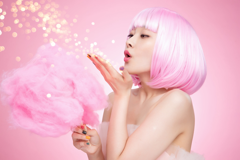 拿着棉花糖玩耍的年轻女孩照片 拿着棉花糖玩耍的年轻女孩照片