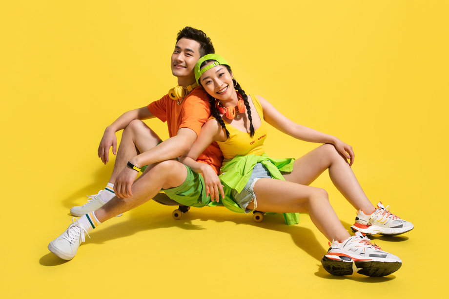 坐在滑板上的个性青年情侣