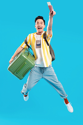 抱着行李箱去旅行的年轻男人