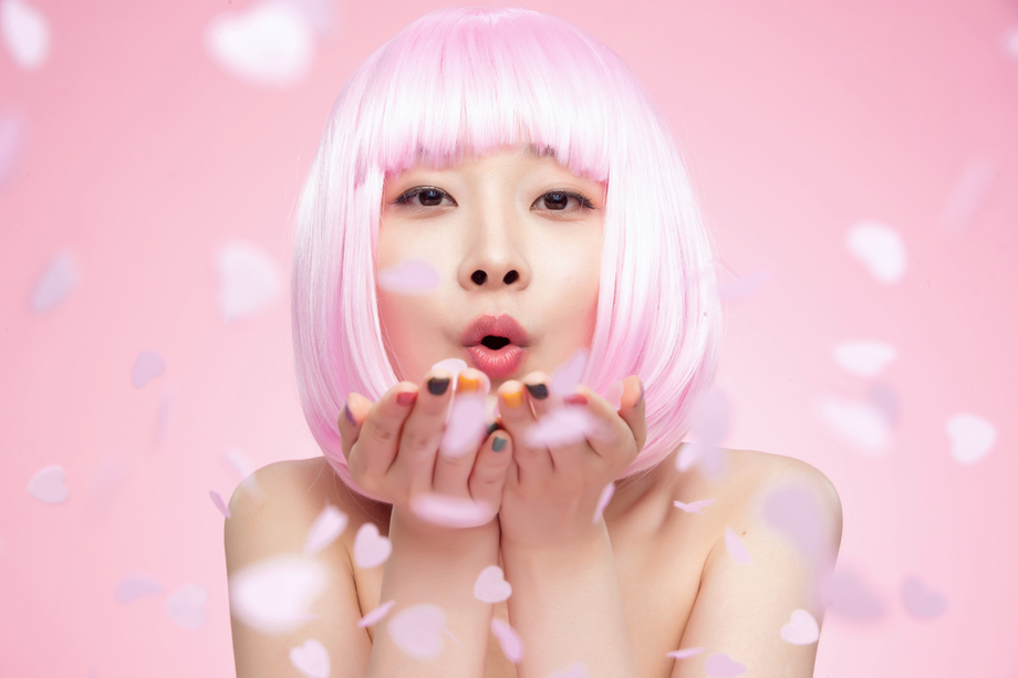 年轻女孩吹撒手中的心形纸片图片