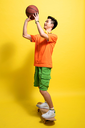 滑着滑板投篮的青年男人图片