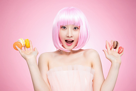 手指夹满马卡龙的年轻女孩