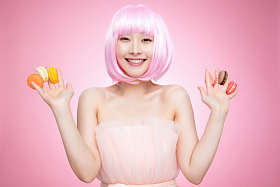 手指夹满马卡龙的快乐女孩图片