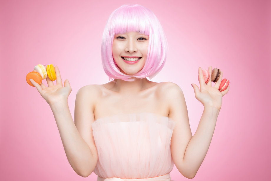手指夹满马卡龙的快乐女孩图片