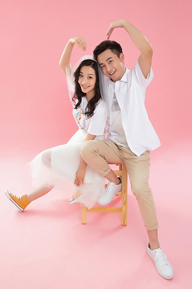 快乐情侣在床上做心形造型照片