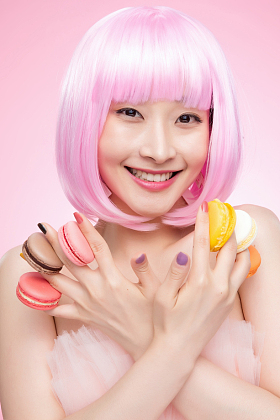 手指夹满马卡龙的漂亮女孩图片