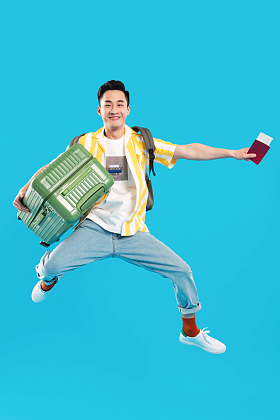 抱着行李箱去旅行的年轻男人