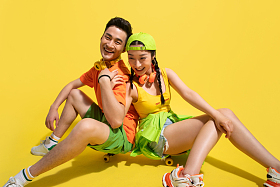 坐在滑板上聊天的青年情侣照片