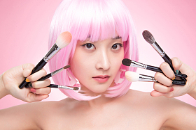 手指夹满化妆刷的个性女孩图片