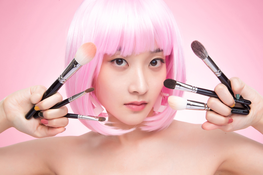 手指夹满化妆刷的个性女孩图片