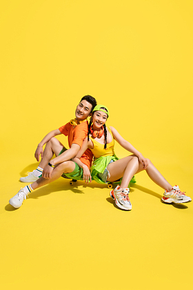 坐在滑板上的时尚青年情侣