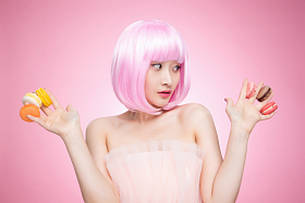 看着手指夹满马卡龙的时尚女孩