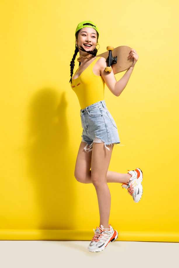 快乐的青年女人背着滑板