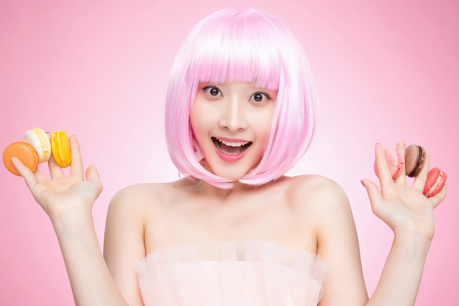 手指夹满马卡龙的快乐女孩