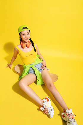 坐在滑板上休息的青年女人图片