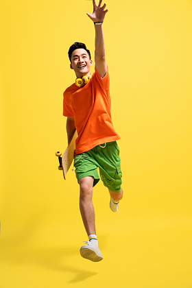 拿着滑板跳跃的快乐青年男人图片