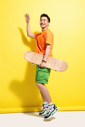 拿着滑板的快乐青年男人