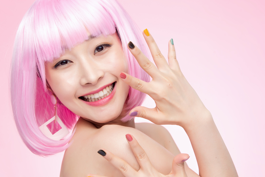 展示彩色指甲油的时尚年轻女人