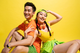 背靠背坐着的时尚青年情侣