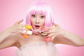 手指夹满马卡龙的时尚女孩照片